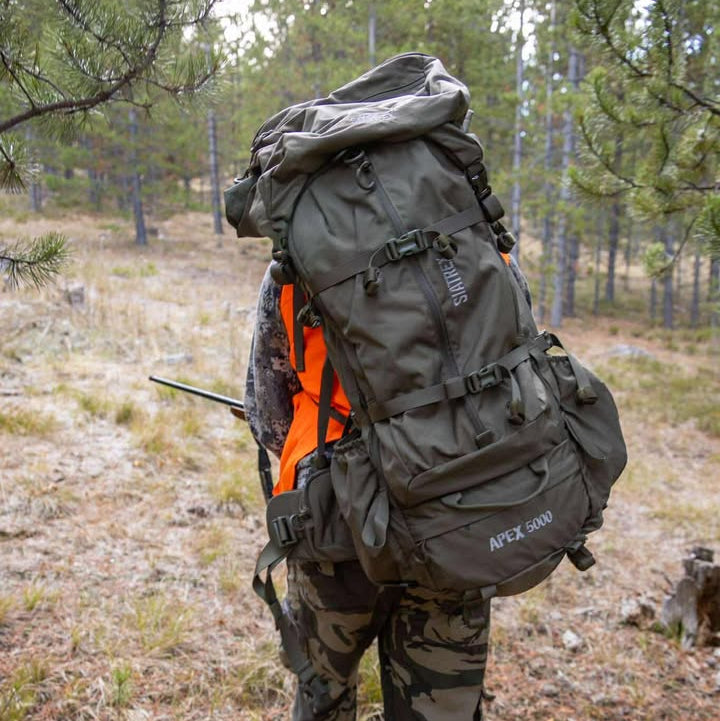 SIATREX APEX 5000 backpack in outdoor wilderness, showing multiple pockets and carbon fiber frame