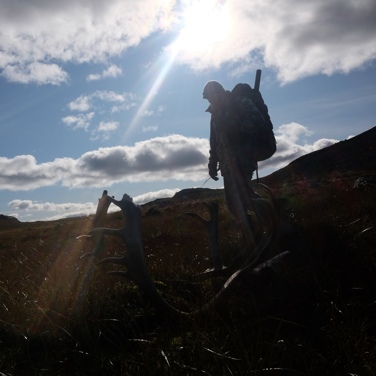 Hunter carrying a carbon fiber frame backpack through rugged mountain terrain during an expedition hunt — SIATREX APEX 5000 ultralight hunting pack