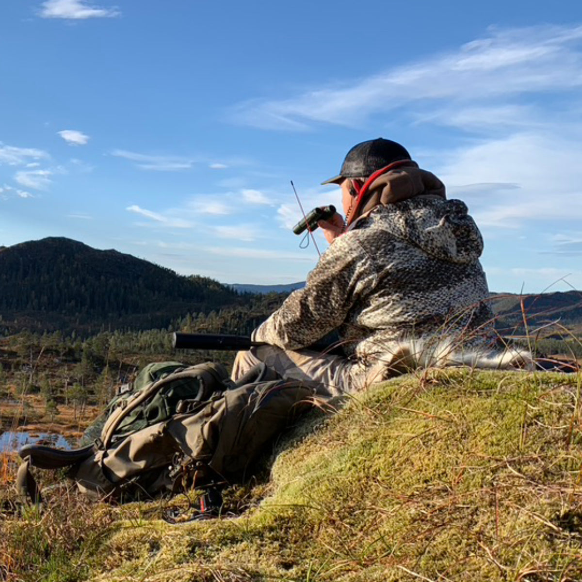 Hunter wearing the SIATREX BINO-X binocular harness connected to the APEX 5000 carbon frame pack during a backcountry hunt