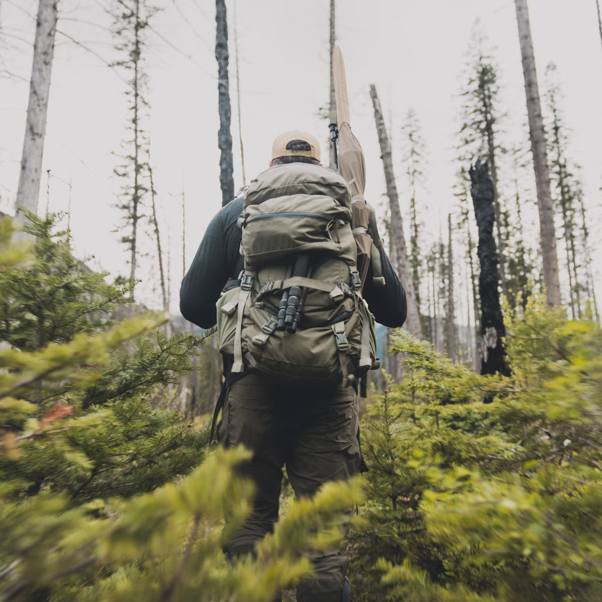 Hunter adjusting a backpack in the mountains, showing correct weight distribution with SIATREX APEX 5000.